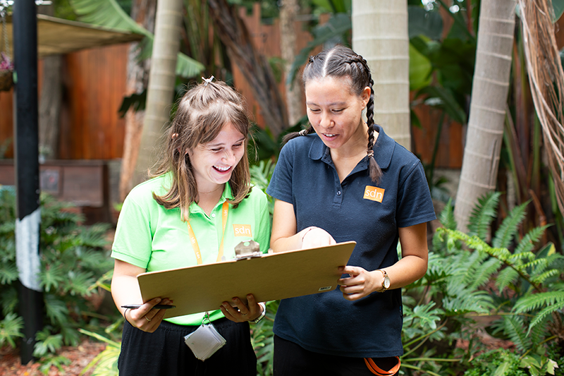 Two people reading a clipboard